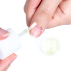 Contagocce che applica l'olio per cuticole sul contorno dell'unghia