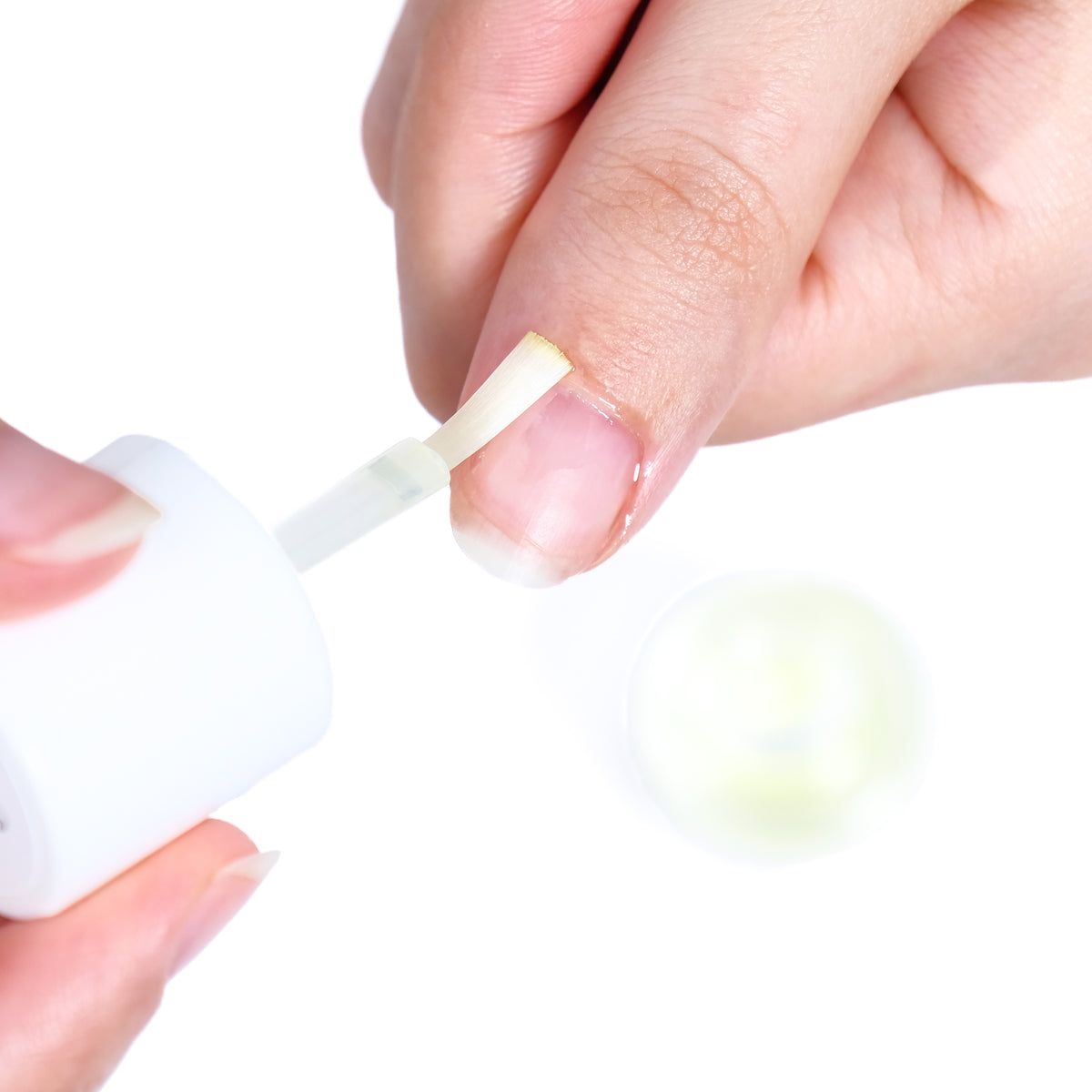Contagocce che applica l'olio per cuticole sul contorno dell'unghia